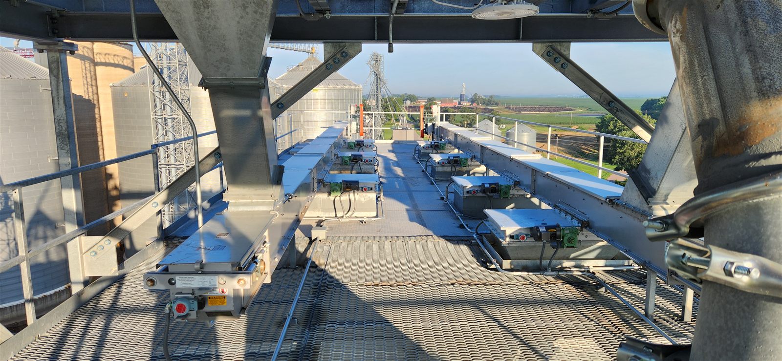 Bin fill deck and distributor equipment atop a grain facility