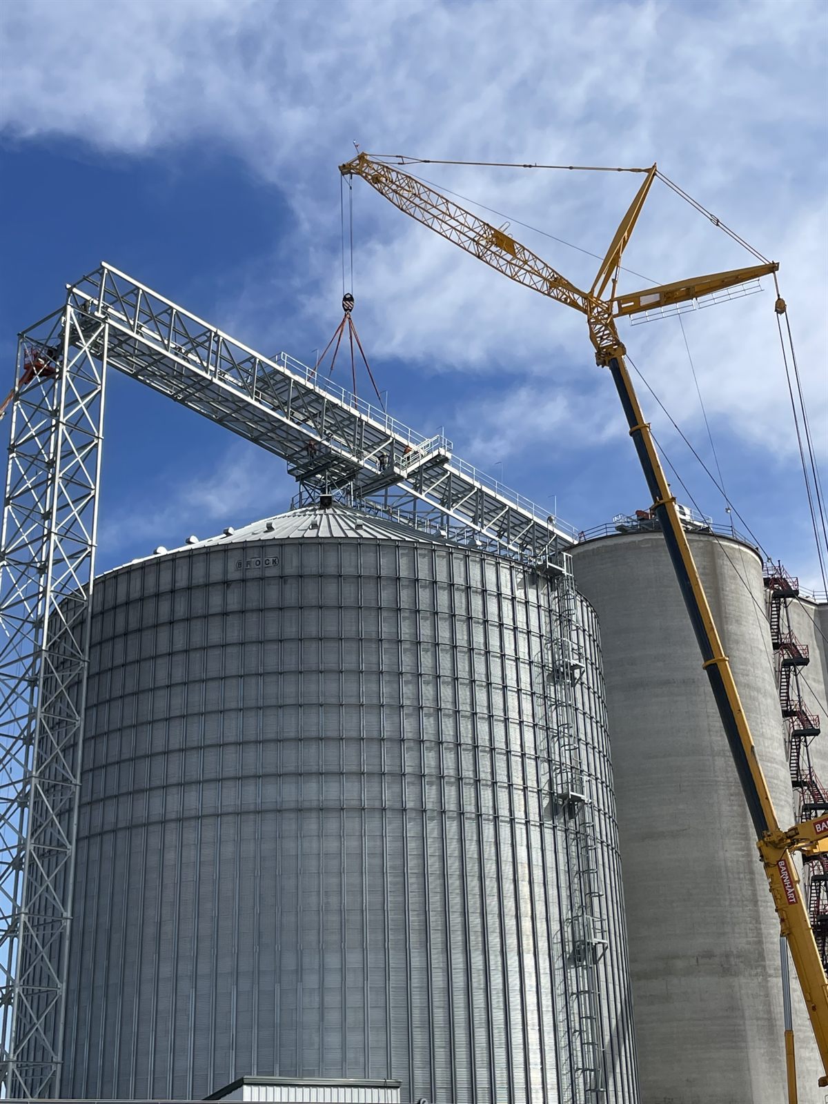 Crane setting a grain bin section into place