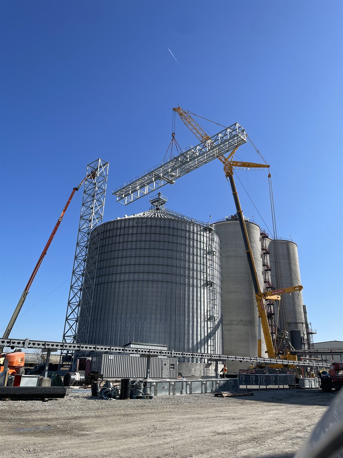 Tandem crane lift setting a grain bin section into place
